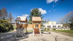 einen Spielplatz mit Baumhaus und Rutsche in der Unterkunft Hotel Mukran in Sassnitz