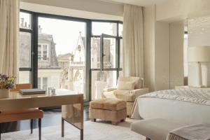 een slaapkamer met een bed, een bureau en een stoel bij Cheval Blanc Paris & Dior Spa Cheval Blanc Paris in Parijs