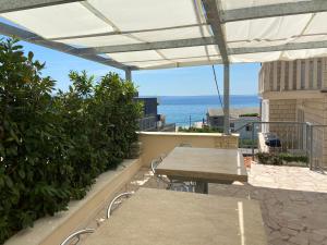 d'une terrasse avec des tables et une vue sur l'océan. dans l'établissement Apartments Toni 2000, à Podstrana