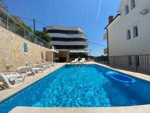 une piscine avec des chaises et un bâtiment dans l'établissement Apartments Toni 2000, à Podstrana