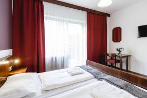 um quarto com uma cama com cortinas vermelhas e uma janela em Hotel Hoffinger em Viena