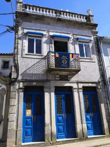 budynek z niebieskimi drzwiami i balkonem w obiekcie Bom Caminha - Private Albergue for Pilgrims w mieście Caminha