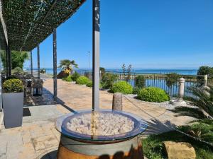 una fuente de agua con la playa en el fondo en Hotel Lavender - Oleander Resort, en Strunjan