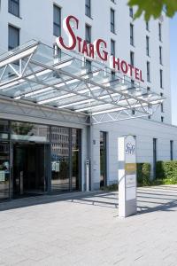 a sign for a star hotel in front of a building at Star G Hotel Premium München Domagkstraße in Munich