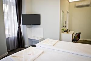 Giường trong phòng chung tại Plovdiv City Center Hotel