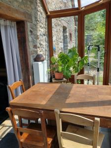 una mesa de madera y sillas en una habitación con ventana en Maison Druyard huis met 5 slaapkamers, en Durbuy