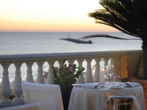 einen Tisch mit Meerblick und einem Boot in der Unterkunft GH Palazzo Suite & SPA in Livorno