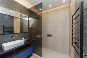 y baño con lavabo y espejo. en Level 24 - Sea & Sky View Apartment, en Odessa