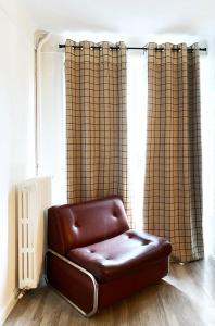 a brown leather chair sitting in front of a window at Relais Des Villards in Séez