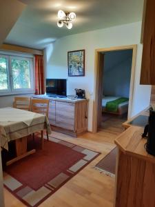 sala de estar con mesa y dormitorio en Landgasthof Hubertusstubn, en Sankt Michael im Lungau