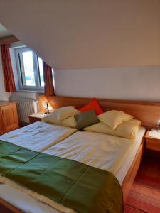 Cama grande en habitación con 2 ventanas en Landgasthof Hubertusstubn, en Sankt Michael im Lungau