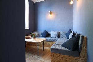 a living room with a blue couch and a table at Blue Doors Hostel KTV in Rostock