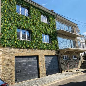 un edificio con dos puertas de garaje y una planta en The Splendid View - 8 Personnes, en Bouillon