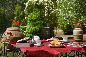 uma mesa com pratos de comida numa toalha de mesa vermelha em B&B Villa Giulia em Saturnia