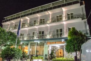 ein weißes Gebäude mit Balkon in der Nacht in der Unterkunft Telis Hotel in Egio