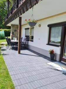 een patio van een huis met een tafel en stoelen bij FEWO Paternoster in Regen