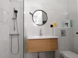 La salle de bains est pourvue d'un lavabo et d'un miroir. dans l'établissement Apartment Cannes Gallia Grand Park, à Cannes