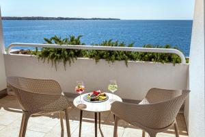 un tavolo e sedie su un balcone con vista sull'oceano di Hotel Histrion a Portoroz