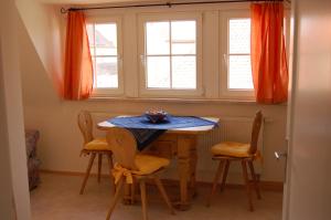 a table and chairs in a room with windows at Ferienwohnung Heinrichseck in Bamberg