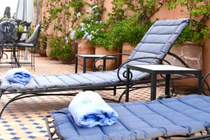 2 sedie e un divano blu su un patio di Riad Yacout a Meknès