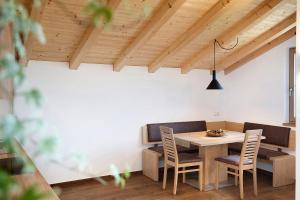 een eetkamer met een houten tafel en stoelen bij Unterötzbauerhof - Fewo Rosenblick in Tirolo