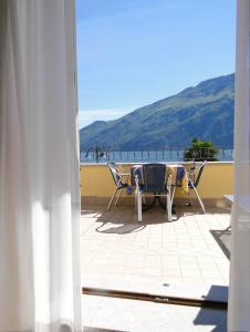 patio con sedie, tavolo e vista sull'oceano di Hotel Sole - Limone a Limone sul Garda