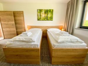 two twin beds in a room with a window at Sport HOTEL Bečva in Valašské Meziříčí