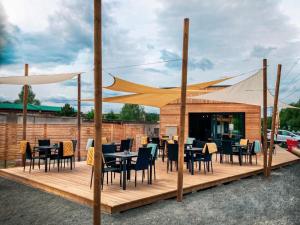 a restaurant with tables and chairs on a wooden deck at Sport HOTEL Bečva in Valašské Meziříčí