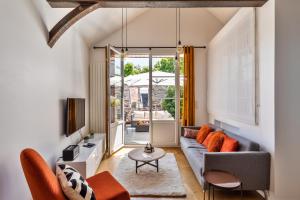 a living room with a couch and a table at Maison Sévigné - Le calme du Thabor et la proximité du centre ville in Rennes