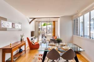 a living room with a glass table and chairs at Maison Sévigné - Le calme du Thabor et la proximité du centre ville in Rennes