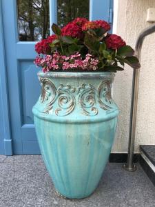 um grande vaso azul com flores na frente de uma porta em Hotel Sundblick em Altefähr