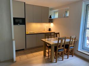 een keuken met een tafel en stoelen in een kamer bij Pilkopė in Nida