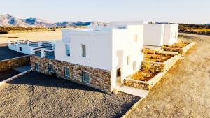 ein weißes Gebäude in der Wüste mit Bergen im Hintergrund in der Unterkunft Aeris suites pori semi basement villa in Koufonisia