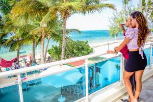 une femme debout sur un balcon donnant sur la plage dans l'établissement Green Coast Beach Hotel, à Punta Cana