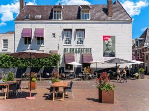 un edificio con mesas y sombrillas delante en Beautiful apartment in city center, en Leeuwarden