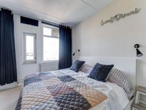 1 dormitorio con 1 cama grande y cortinas azules en Beautiful apartment in city center, en Leeuwarden