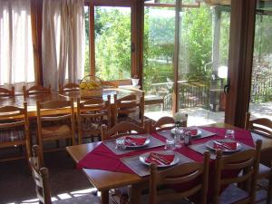 une salle à manger avec des tables et des chaises ainsi qu'une grande fenêtre dans l'établissement Porto Lourba, à Galaxidi