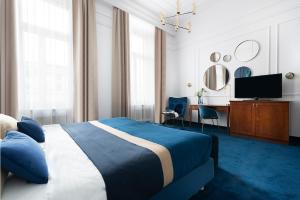 una camera con letto, scrivania e TV di IBB Hotel Grand Hotel Lublin a Lublino