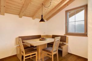 een eetkamer met een houten tafel en stoelen bij Unterötzbauerhof - Fewo Rosenblick in Tirolo