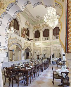 ein Esszimmer mit einem langen Tisch in einem Gebäude in der Unterkunft Alsisar Haveli - Heritage Hotel in Jaipur