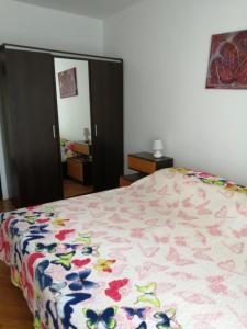 una camera con un letto e un piumone floreale di Apartment Vilma a Rovigno (Rovinj)