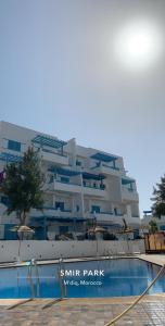 Smir Park appartement Haut standing Marina Smir في مارينا سمير: مبنى فيه مسبح امام مبنى