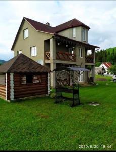 ein großes Haus mit einem Balkon und einem Haus in der Unterkunft Карпатські Зорі in Pilipets