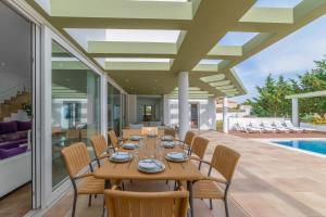 een eetkamer met een tafel en stoelen en een zwembad bij Villa Santandria Grupo Seranova Luxury Hotel in Ciutadella