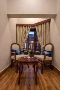 a living room with a table and chairs and a window at Khattak Lodge Murree in Murree