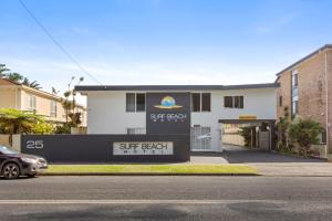 a white building with a sign in front of it at Surf Beach Motel Coffs in Coffs Harbour