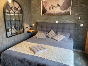 Un dormitorio con una cama con almohadas. en HOTEL NATURE LE LOFT, en Pierrelatte