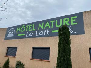 una señal en el lateral de un hotel naturele lot en HOTEL NATURE LE LOFT, en Pierrelatte