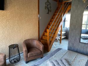 sala de estar con escalera y silla en HOTEL NATURE LE LOFT, en Pierrelatte