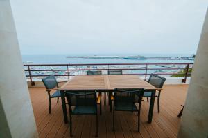 un tavolo e sedie su un balcone con vista sull'oceano di Rooftop Marina l by Madeira Best Apartments a Funchal